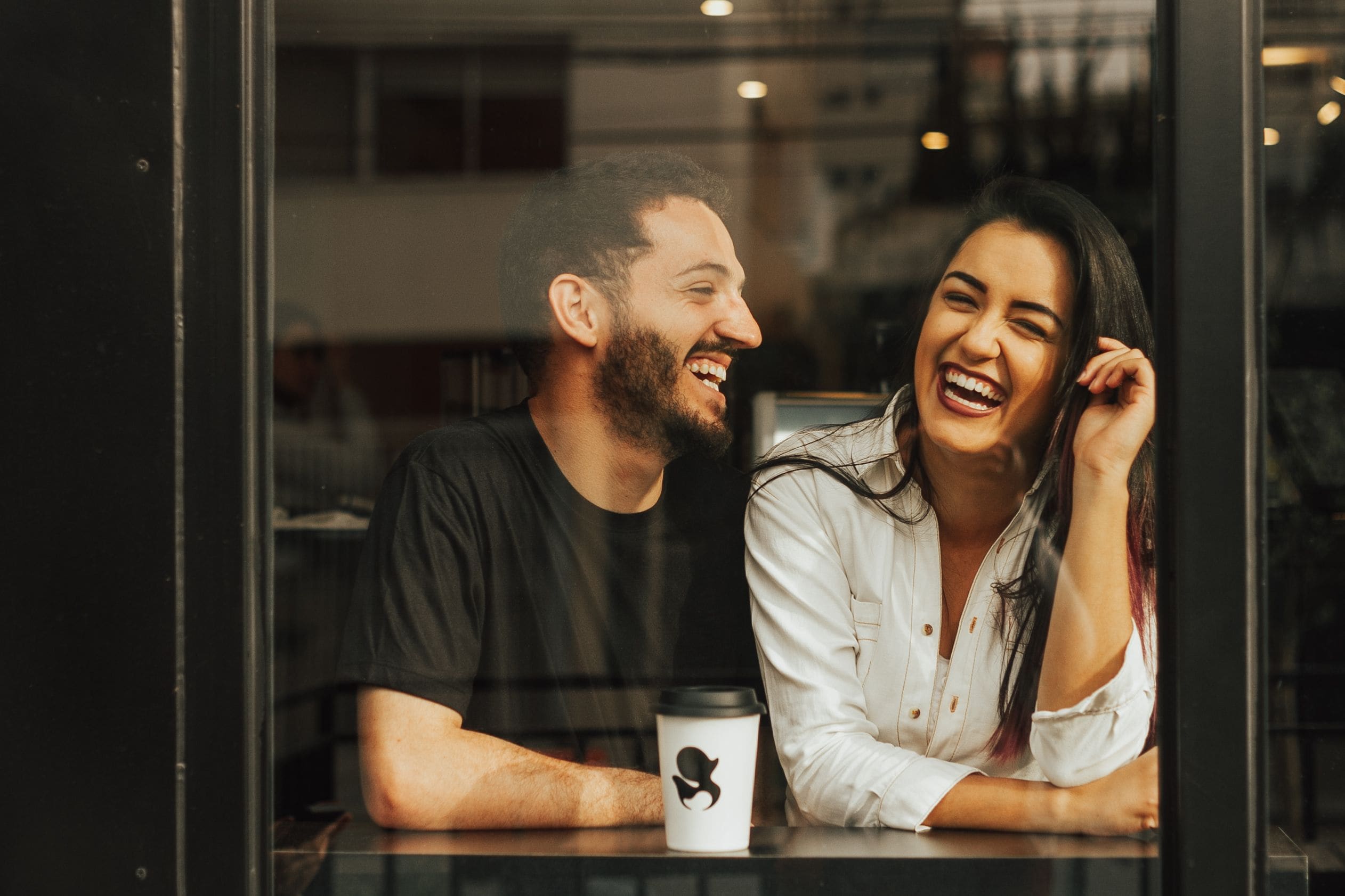 Two people laughing together in a café